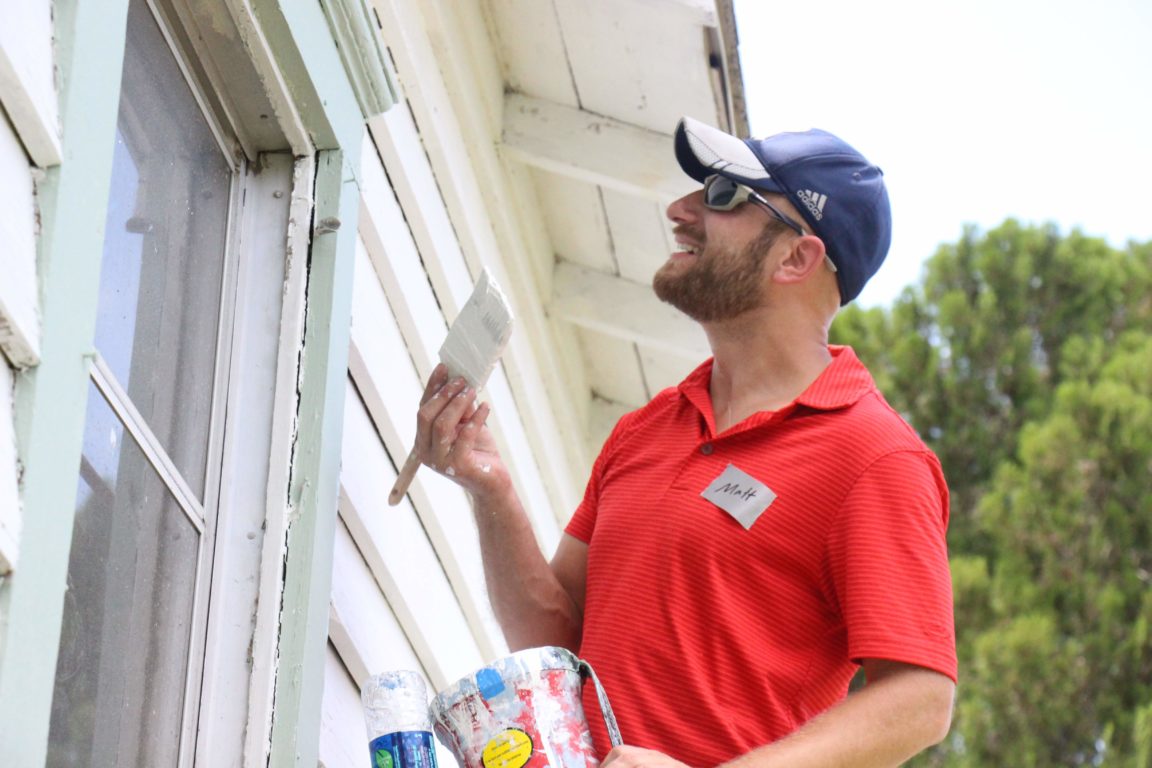 Matt Cheney (2001 Scholar) paints siding.