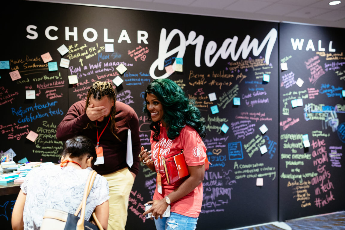 Robert Jackson (2012) and Ericka Dunlap (2000) share a laugh in from the the Scholar Dream Wall, where Scholars would write a problem they wanted to solve, and others would reply with ideas or solutions.